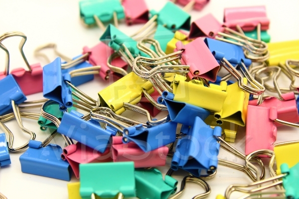 Colorful office clips waiting for piles of documents to fasten